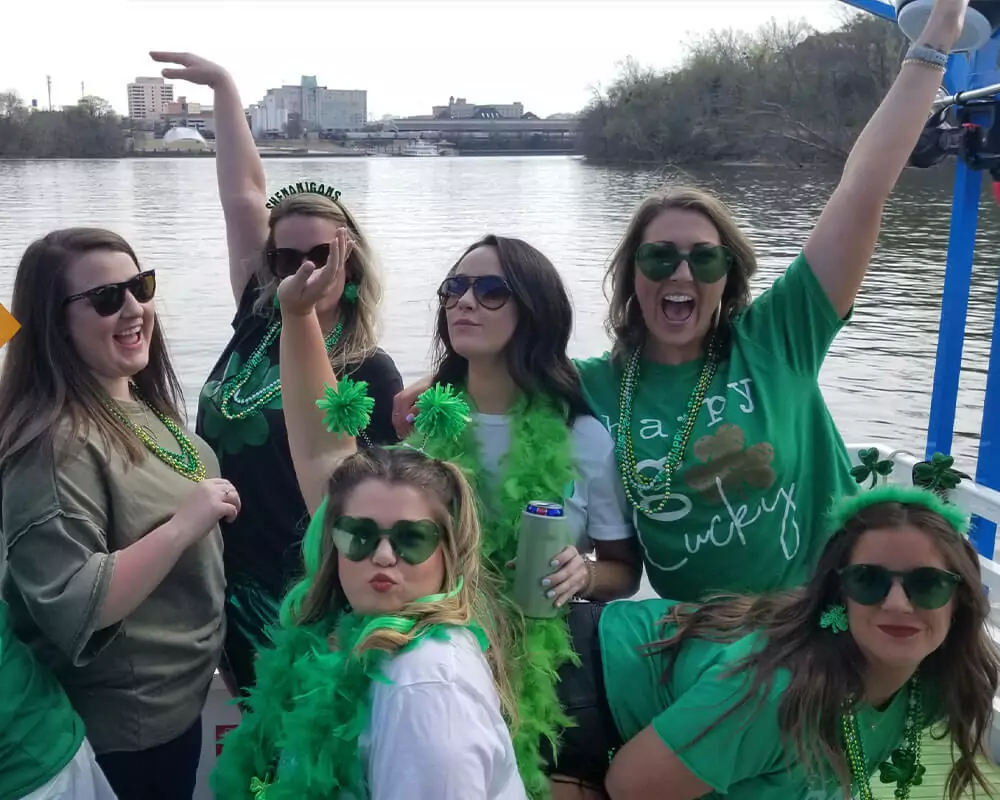 girls dressed in green posing for a picture on a pedal cruise