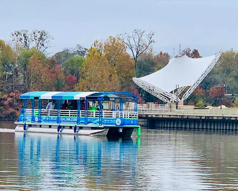 green and blue sip n cycle pedal cruiser on the water